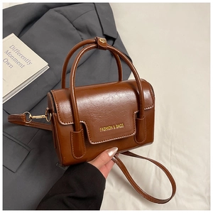 Détail du petit sac carré en cuir marron texturé avec inscription Fashion & Bags