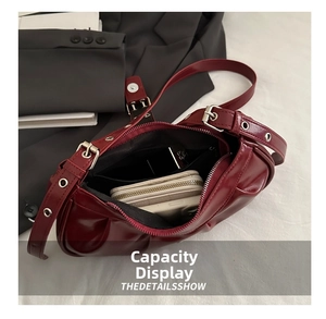 Interior view of wine red pleated shoulder bag showing storage for phone and wallet