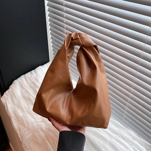 Minimalist caramel brown pleated bucket handbag with unique twist handle design