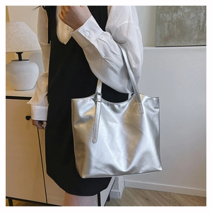 Dettaglio della borsa tote argento metallizzato con fibbia sulla tracolla sottile