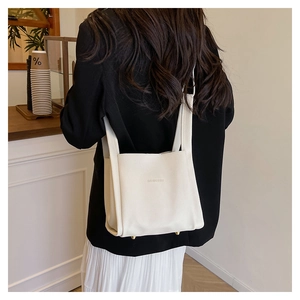 Detail of white lychee grain leather tote bag with protective gold base studs