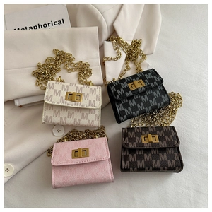 Close-up of stylish mini chain square bags with gold turn-lock and M-pattern print