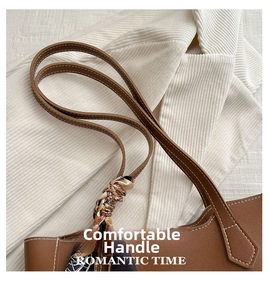 Détail d'un cabas en cuir marron avec un foulard en soie géométrique noué à l'anse