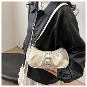 Detail of cream white pleated underarm bag with silver metallic belt buckle hardware