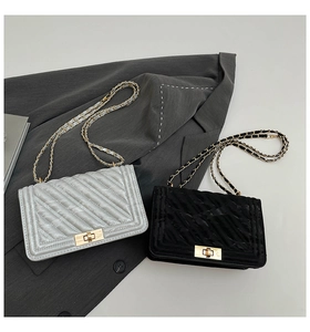Detail of silver-blue and black quilted crossbody bags with chain straps and metal locks