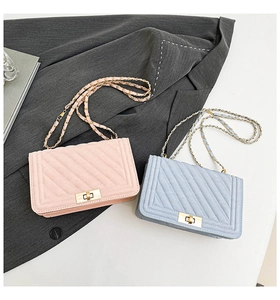 Detail of V-quilted chain bags in pastel pink and blue with golden turn-lock closure