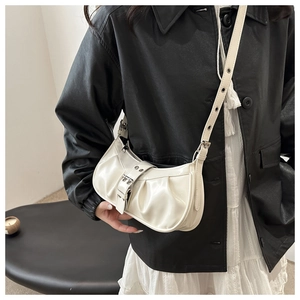 Chic cream white pleated underarm bag with decorative buckle shown on a model