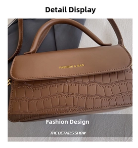 Detail of brown stone-patterned handbag with golden brand lettering and textured finish