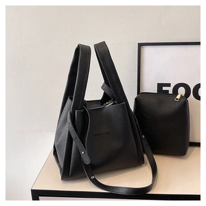 Detail of black lychee grain leather bucket bag with inner pouch and logo branding
