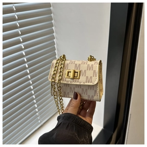 Close-up of mini square chain bag featuring M-letter print and golden twist lock
