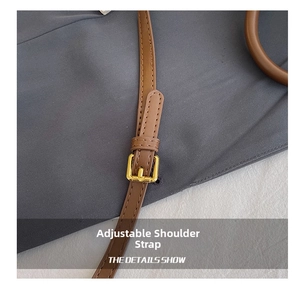 Detail of adjustable brown leather shoulder strap with gold-tone metal buckle hardware