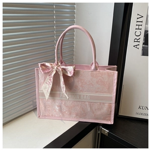 Pink jacquard tote bag with silk scarf detail and Fashion Bag text on white ledge