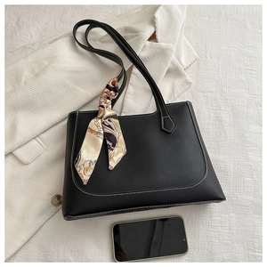 Détail du sac cabas noir avec coutures blanches contrastées et foulard en soie élégant