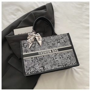 Detail view of floral canvas tote bag featuring Fashion Bag ribbon and silk scarf handle