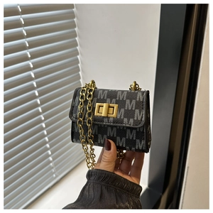 Detail of mini crossbody bag with golden twist lock and signature M-pattern print