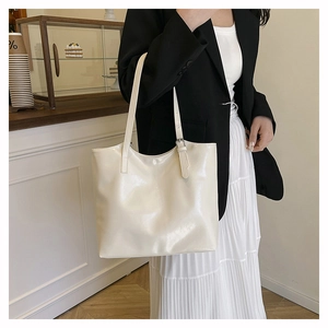 Dettaglio della borsa tote bianco crema in pelle lucida con sottili doppie tracolle