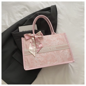 Detailed close-up of pink tote bag featuring fashion ribbon and stylish floral silk scarf