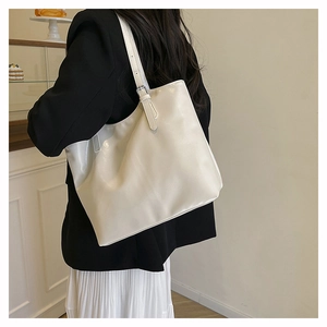 Detail view of cream white PU leather tote bag with adjustable shoulder strap and hardware