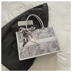 Detail of silver floral tote bag with silk scarf handle and Fashion Bag text logo