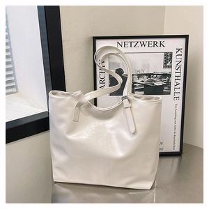 Dettaglio della borsa tote in pelle PU crema con spalline sottili e fibbia in metallo