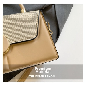 Detail of woven flap and beige leather shoulder bag with round golden metal buckle