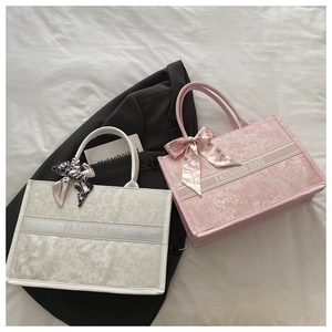 Detailed view of floral tote bags in white and pink with decorative silk scarves