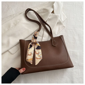 Détail du sac cabas marron foncé avec surpiqûres blanches et foulard en soie à fleurs