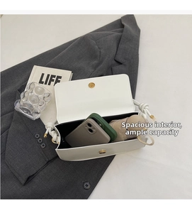 Spacious interior of white crossbody bag holding two smartphones and a small umbrella