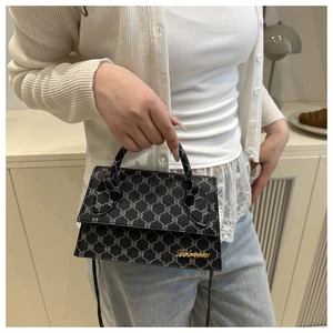 Détail du sac cabas en toile géométrique grise avec logo doré et poignée chic