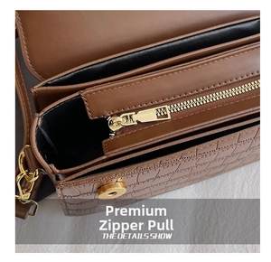 Close-up of brown crocodile texture leather bag with golden zipper and magnetic closure