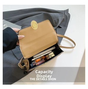 Detail showing spacious interior capacity of the khaki leather crossbody bag with items