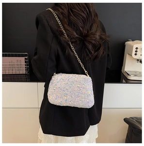 Détail d'un sac à bandoulière à paillettes colorées avec chaîne dorée sur un mannequin