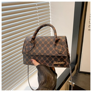 Détail d'un mini sac bandoulière vintage avec monogramme marron foncé et logo doré