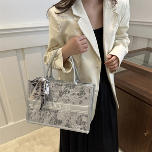 Silver floral tote bag with silk scarf accent and Fashion Bag text in a handheld shot