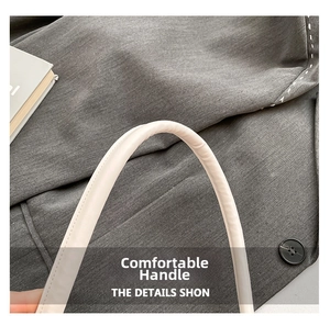 Close-up of the cream leather handle showing fine stitching and soft texture on the bag