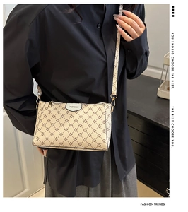 Dettaglio della borsa a tracolla beige monogramma con logo fashion e finiture metalliche