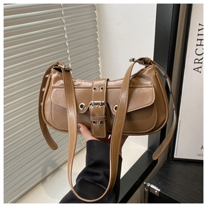 Detail of vintage brown leather underarm bag with silver buckle and grommet eyelets