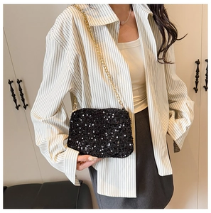 Détail d'un sac à bandoulière chic à paillettes noires avec une chaîne dorée sur mannequin