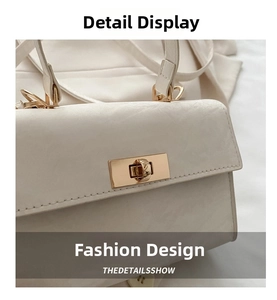 Detail of elegant gold metal twist lock on white leather minimalist handbag