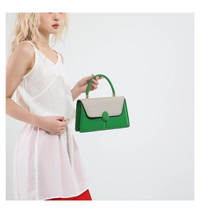 Green and beige color-block small handbag styled by a model with a casual white top