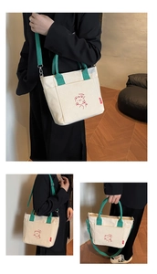 Detail view of canvas tote bag featuring cute cartoon bear print and green straps