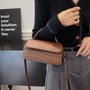 Brown crocodile-textured handbag with gold FASHION & BAG lettering and adjustable strap
