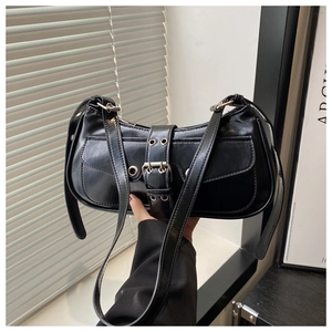 Close-up of a matte black French baguette bag with metal buckle and leather strap