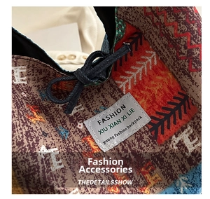 Close-up of ethnic patchwork fabric on shoulder bag showing colorful patterns and label