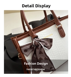 Detail of white crocodile pattern tote with brown trim and heart print scarf decoration