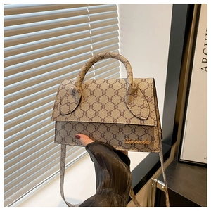 Gros plan du sac à main vintage à carreaux avec logo en métal et poignée