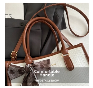 Macro shot of faux leather tote bag featuring comfortable handles and a decorative silk scarf