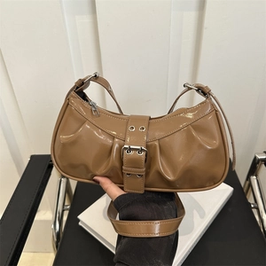 Retro brown wrinkled leather underarm bag with silver buckle strap shown in a hand