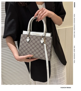 Detail of clover pattern handbag with white leather handle and gold metal hardware