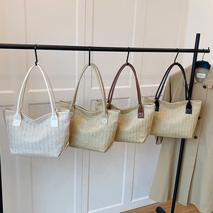 Minimalist woven straw tote bags in various colors hanging for fashion spring collection
